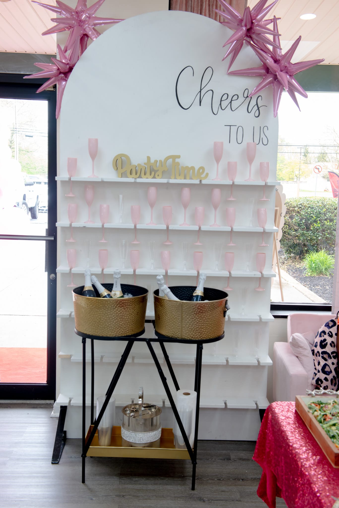 Cheers to Us champagne wall with pink glasses and gold ice buckets — spa party near me Middletown Delaware