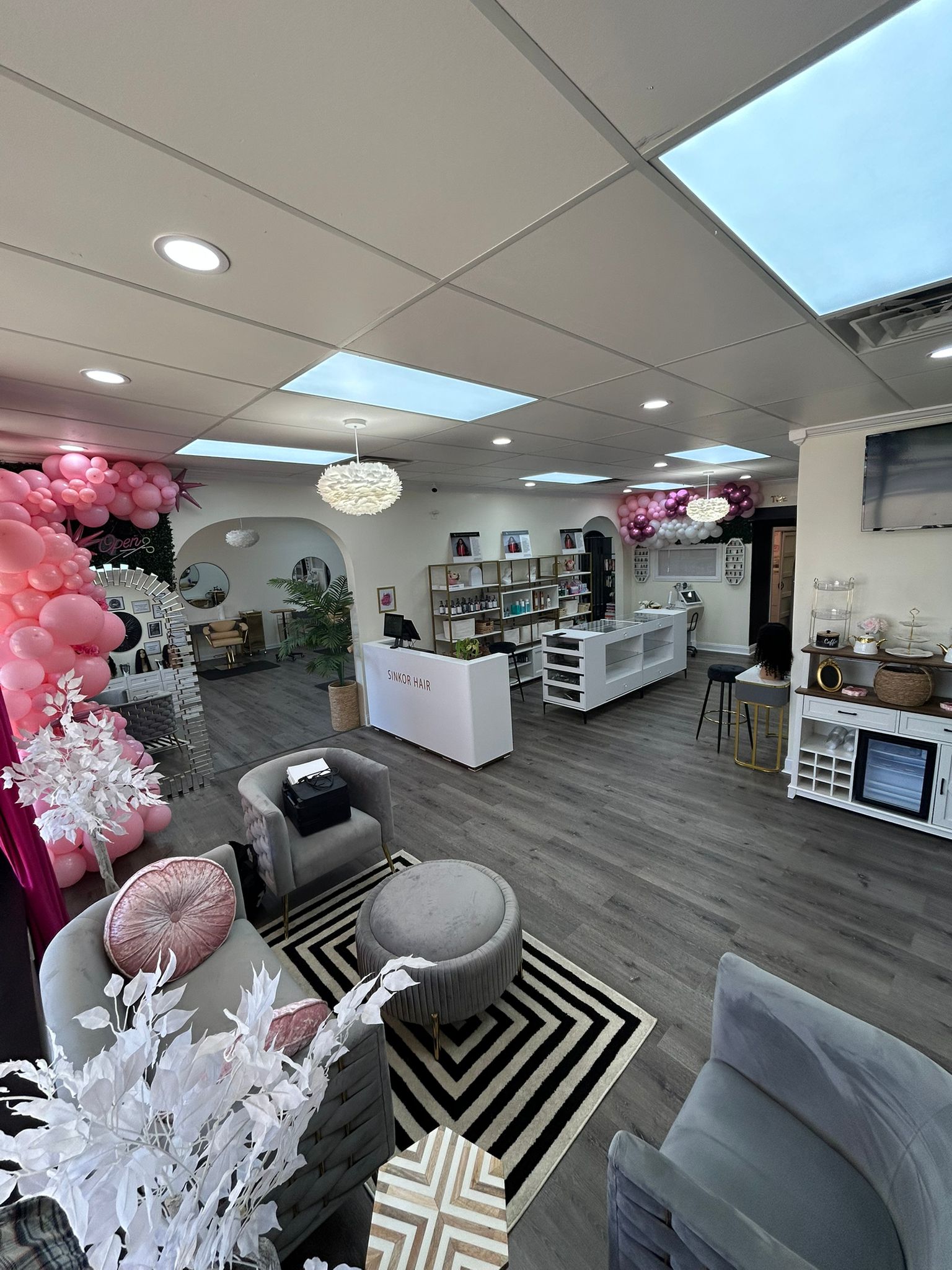 Full Sinkor Beauty Salon venue with pink balloon garlands, lounge seating, reception desk — private spa party venue Middletown DE