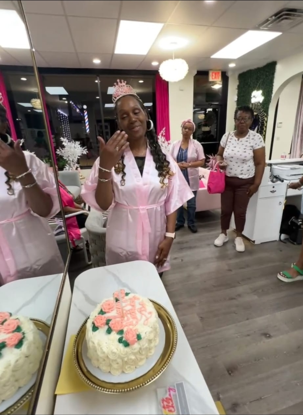 Birthday girl in pink robe with tiara beside birthday cake at Sinkor spa party Middletown DE